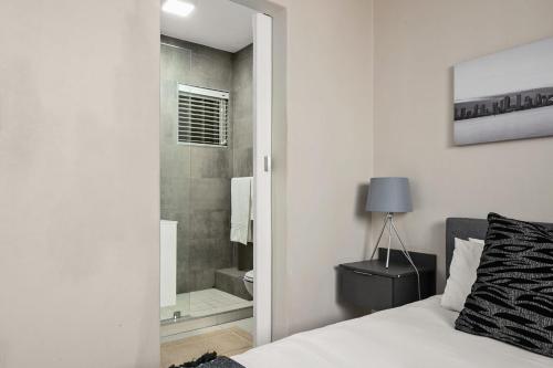 约翰内斯堡Marley on Katherine Apartments的一间卧室配有一张床,浴室设有淋浴。