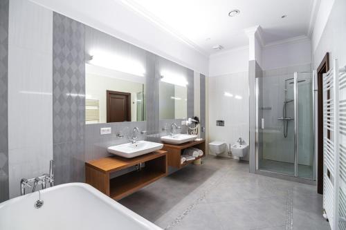 科希策Hotel Michael's Palace的一间带两个盥洗盆和大镜子的浴室