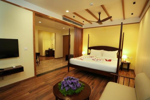 KakkadampoyilMisty Queen By Dimora Hotels的一间酒店客房,配有一张床和一台电视