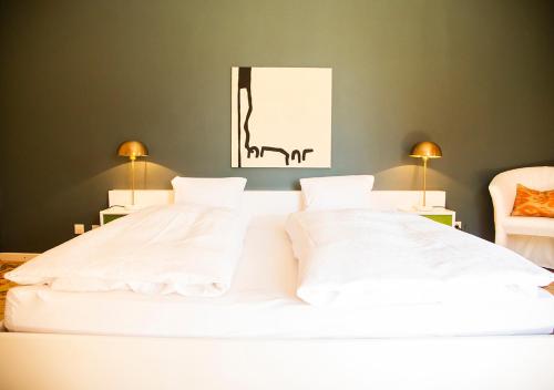 沃尔特湖畔韦尔登Villa Bulfon的卧室内的一张带两个枕头的大型白色床