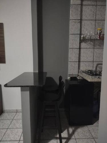 里约布兰科Quarto aconchegante Completo的厨房配有黑色柜台和凳子