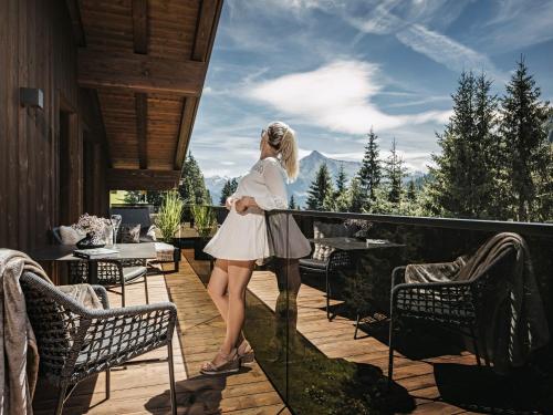 希帕赫Hotel Bergkristall Zillertal的站在山景阳台上的女人
