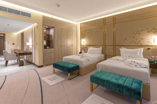 多哈Green Park Hotel的酒店客房配有两张床和一张书桌