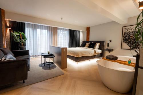 巴勒姆Boetiekhotel Faan - NIEUW!的客房内的浴室设有床和浴缸