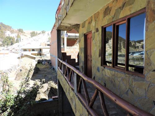 Comunidad ChallapampaTITI QALA HOSTEL的一座带2扇窗户和阳台的建筑