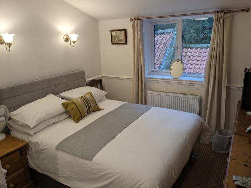 惠特比The Board Inn - Lealholm的卧室配有一张大白色床和窗户
