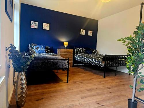 德比Hereford House - Welcome Short Stays的一间设有两张床和蓝色墙壁的客房