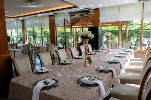 斯库台Buna Park Hotel的长长的用餐室配有长桌子和椅子