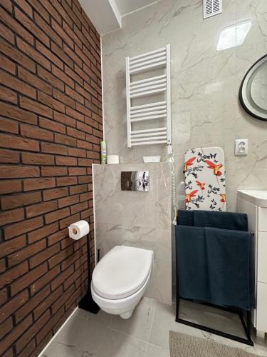 卡托维兹Apartamenty 1-maja 94的浴室设有白色卫生间和砖墙