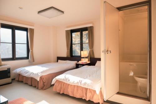 汤泽町豊島ロッヂooバス停浅貝上前的带淋浴的客房内的两张床