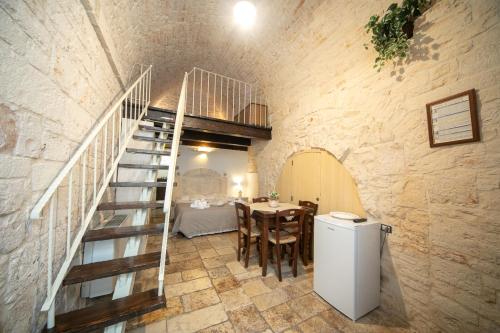 阿尔贝罗贝洛Trulli di Nonno Carlo的厨房以及带楼梯和桌子的用餐室