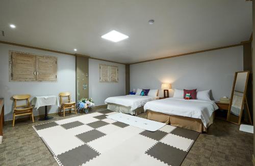扶安Buan Tree California Hotel的酒店客房带两张床、桌子和椅子。