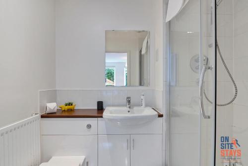 达特福德OnSiteStays - Contemporary 2 Bed Apt with Ensuite, 2 x Free Parking Spaces & a Balcony的白色的浴室设有水槽和淋浴。