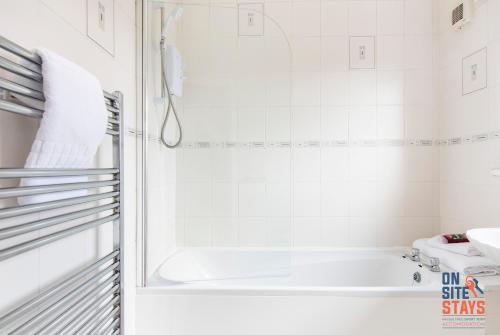 格雷夫森德OnSiteStays - Cosy 2-Bedroom Apartment with Private Entrance & Long Stay Prices的白色的浴室设有浴缸和水槽。