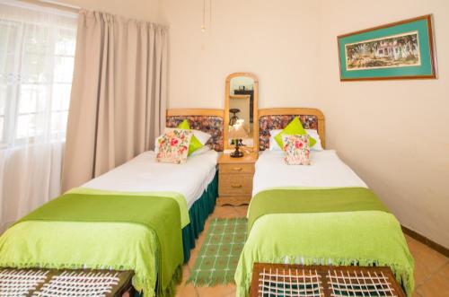 阿多民宿住宿加早餐旅馆的一间卧室配有两张床和镜子