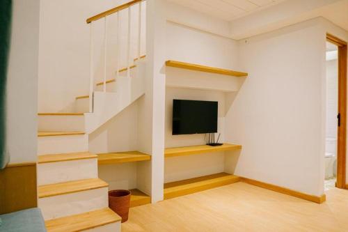 坎古Casa Amarta - Canggu的一间带电视和楼梯间的房间