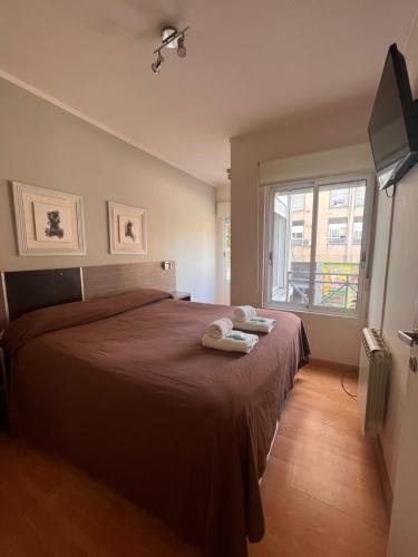 布兰卡港Este Apart的一间卧室配有一张大床和两条毛巾