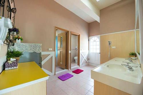 小琉球岛薇多莉亚乡村花园民宿的大型浴室设有水槽和浴缸。