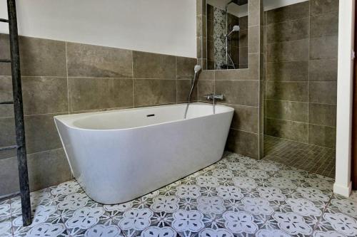 Les MolièresLe Gîte - Le Pressoir的浴室铺有瓷砖地板,配有白色浴缸。