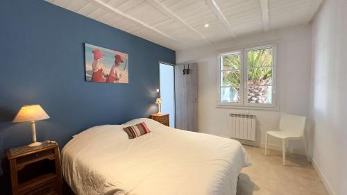 雷岛圣玛丽Superbe villa proche de la mer的卧室配有白色的床和蓝色的墙壁