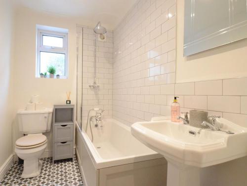 埃文河畔斯特拉特福Manor Road的带浴缸、盥洗盆和卫生间的浴室