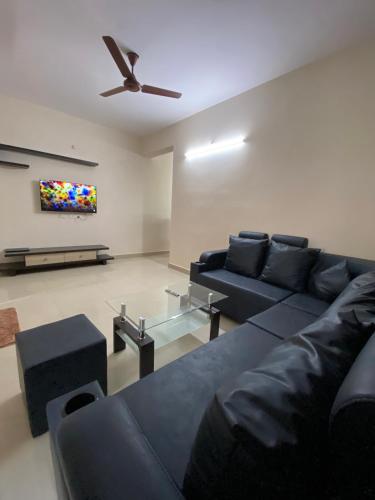 海得拉巴Bigson Service Apartments, Kondapur的带沙发和吊扇的客厅