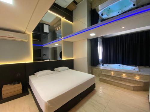 阿雷格里港Drops Motel Porto Alegre的一间卧室配有一张床和一个浴缸