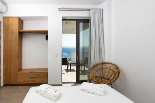 普拉基亚斯"Thea" Luxury Apartments with great View的一间带一张床和一把椅子的卧室以及一个阳台