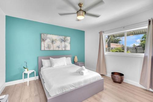 达尼亚滩Blue Wave Bungalow - 1 1 - Stylish的卧室配有白色的床和蓝色的墙壁