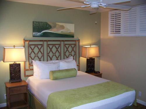 科纳Sea Village的一间卧室配有一张带两盏灯的床和风扇。