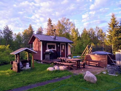 奥卢Onnea talo Haukiputaalla的小屋设有野餐桌和烧烤架