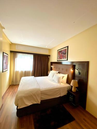 卡萨布兰卡Appart Hôtel Oleandro的一间卧室设有一张大床和一个窗户。