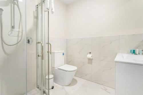 奥克兰Urban Glow Townhouse with parking的白色的浴室设有卫生间和淋浴。