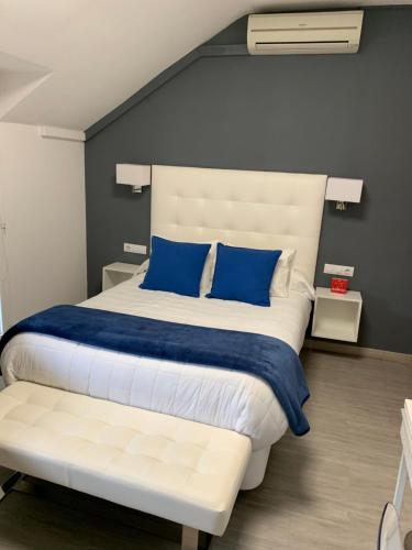 哈拉马河畔帕拉库埃略斯埃尔罗西奥旅馆的一间卧室配有一张带蓝色枕头的大床