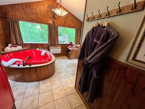 尤里卡斯普林斯Sherwood Court Cottages的一间大浴室,配有红色的浴缸和窗户