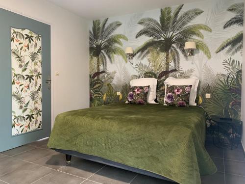 普鲁索昂斯马努瑞古若黛酒店的卧室配有一张绿床,墙上挂着棕榈树