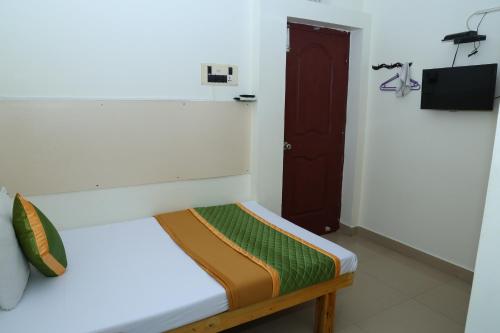 钦奈Royal Green Accommodation Chennai Airport的白色的客房设有一张带棕色门的床