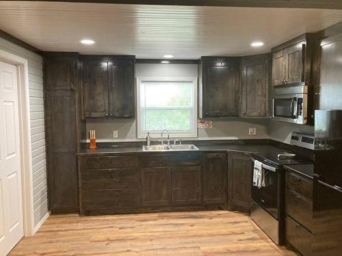 西斯科Lobo Lake Cabin的厨房配有深色木橱柜和水槽