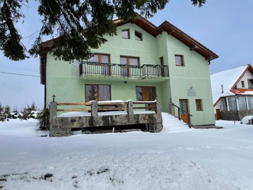PoplacaVila Verde Păltiniș的雪中带围栏的房子