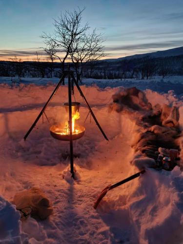 阿尔塔Finnmark Glamping的日落时雪中的一个蜡烛架