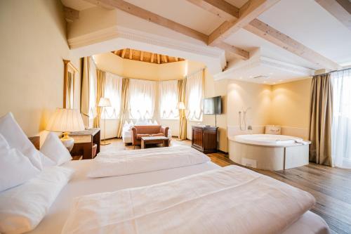瓦尔道拉Hotel Fameli的大房间设有两张床和浴缸
