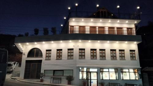 吉诺卡斯特Hotel Bebej Tradicional的白色的建筑,上面有灯
