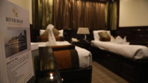 开罗مركب ريفر River Boat的酒店客房,设有两张床和标志