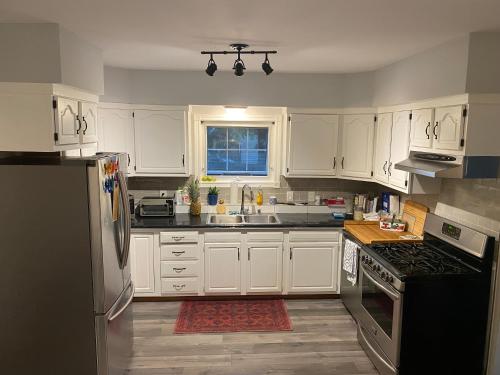 萨尼亚Modern Beach House long stay discounts的厨房配有白色橱柜和黑色冰箱。