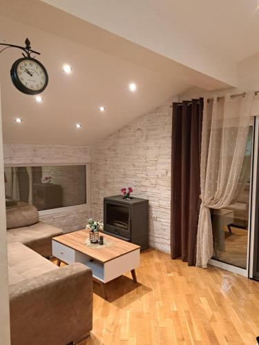 伊加洛Apartman lux REA1的客厅配有沙发和天花板上的闹钟