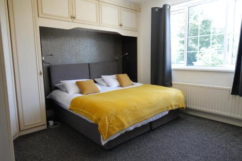 伯明翰Huge 9 Bed Property Sleeps 17, Near NEC, City Centre, HS2的一间卧室配有一张带黄色毯子的大床