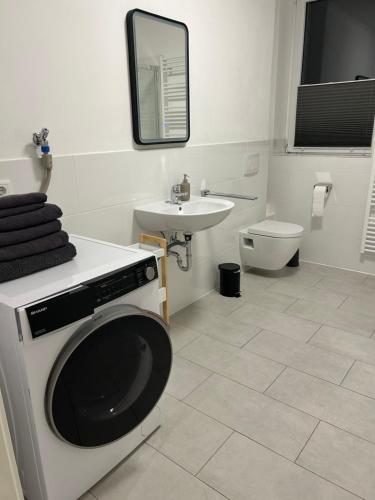 勒讷Wohnen wie zu Hause的一间带洗衣机和水槽的浴室