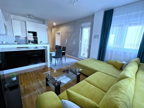 贝尔格莱德Pleasure Lux1 Apartment的一间带绿色沙发的客厅和一间厨房
