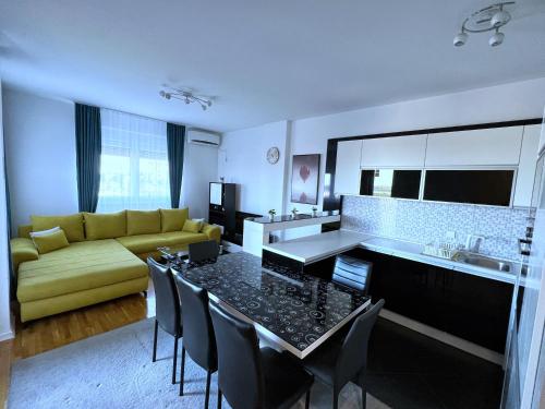 贝尔格莱德Pleasure Lux1 Apartment的厨房以及带桌子和黄色沙发的客厅。