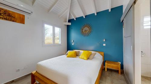 圣罗斯Les maisons Cane的一间卧室设有蓝色的墙壁和一张带黄色枕头的床。